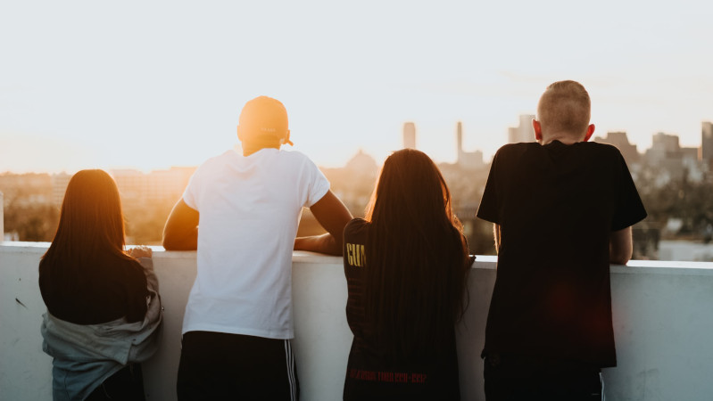 Four young people looking across city scenery 