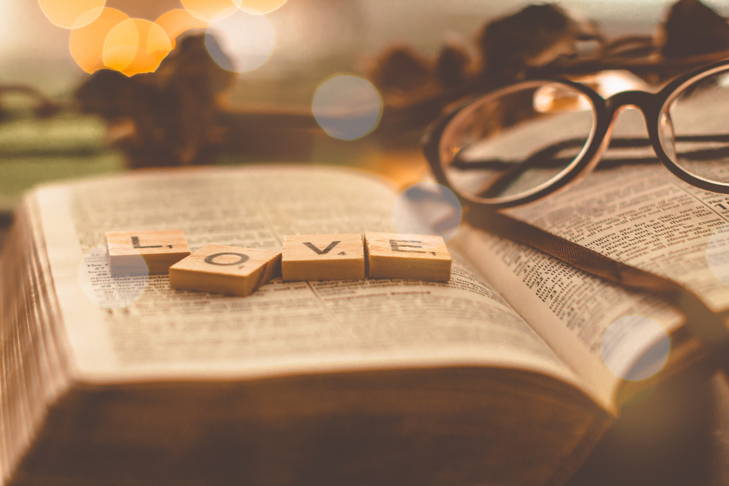 Scrabble tiles spelling love placed on an open Bible