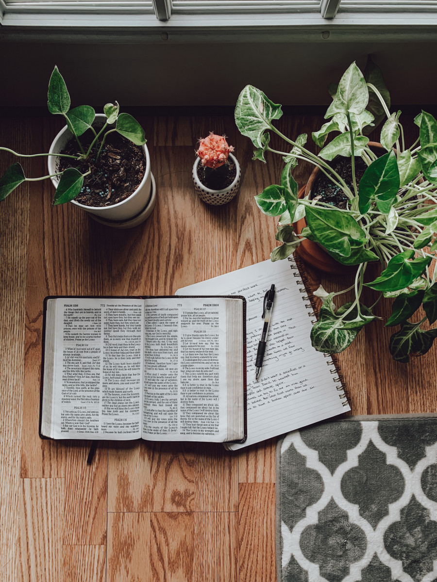 An open Bible and notepad on a desk