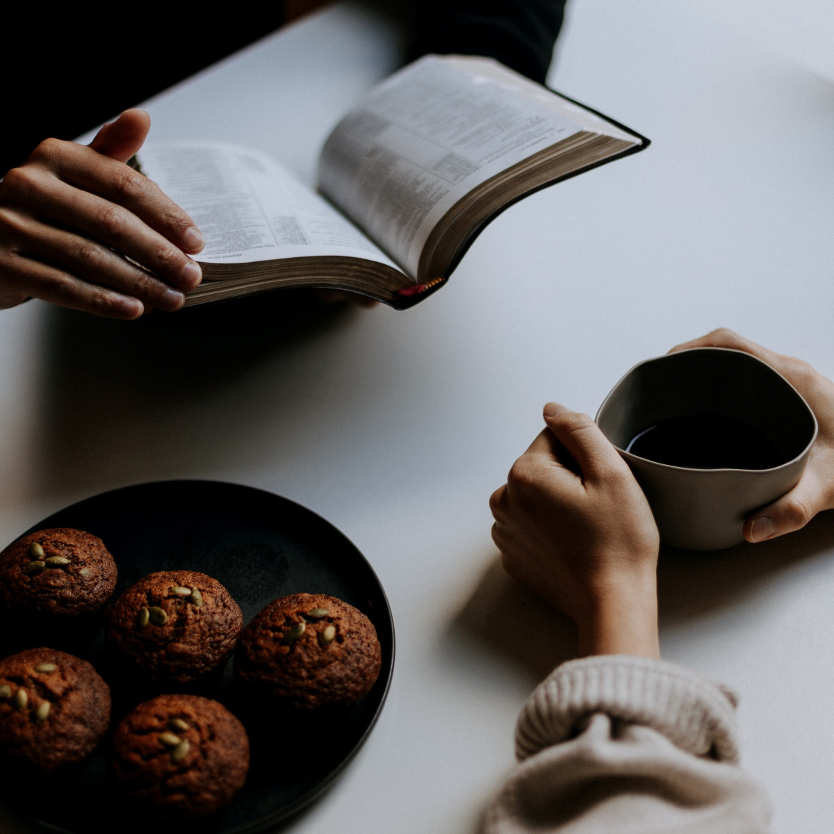 Two people talking about the Bible with a cup of tea and some cake