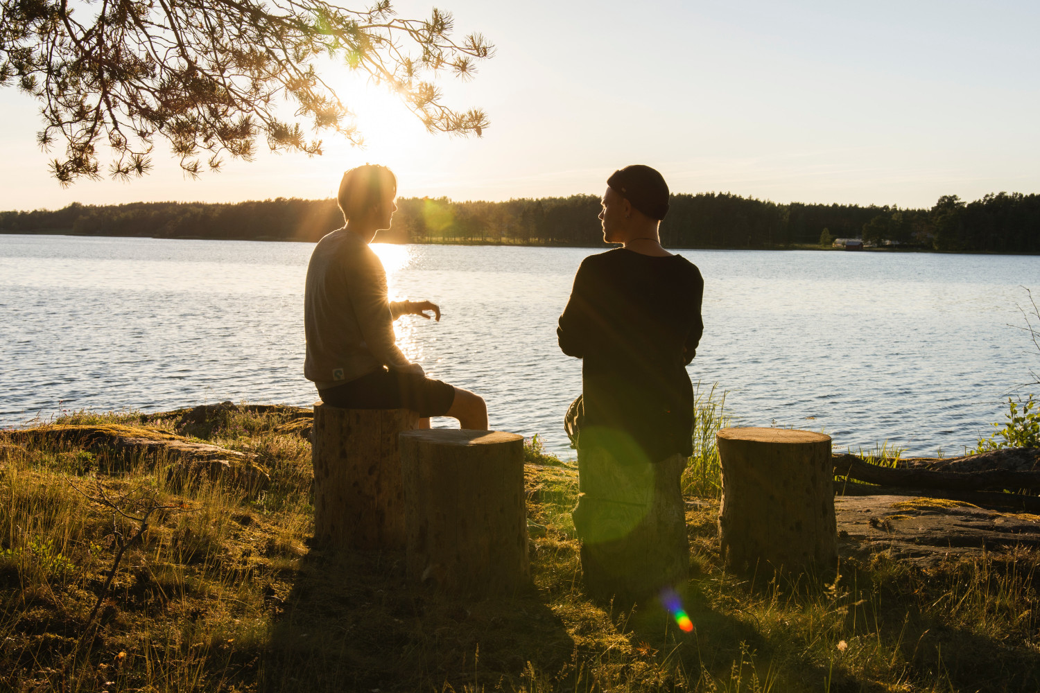 Two people talking by a lake