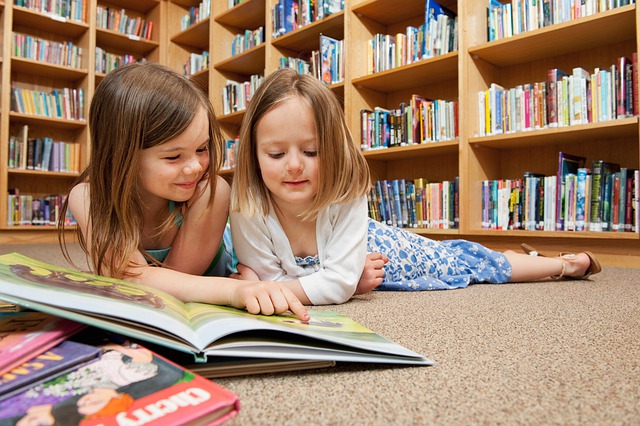 Two children on the floor reading together