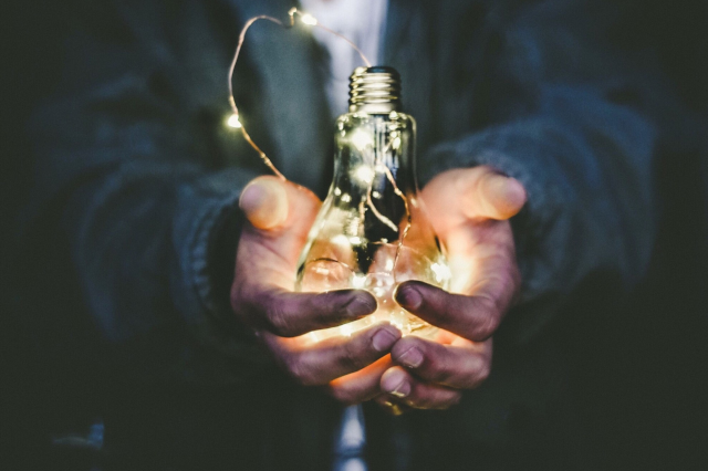 A person holding a lightbulb